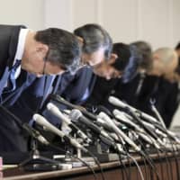 Kansai Electric Power Co.\'s new president Takashi Morimoto (second from left) and his predecessor Shigeki Iwane (left) bow in apology during a press conference in Osaka on March 14. | KYODO
