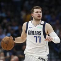Mavericks guard Luka Doncic handles the ball against the Nuggets on March 11 in Dallas. | AP