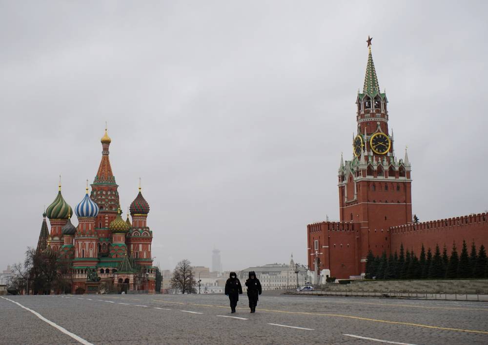 Police officers walk along Red Square on Monday. U.S. spy agencies are finding it difficult to assess the coronavirus outbreak situations in Russia, China and North Korea, according to sources. | REUTERS