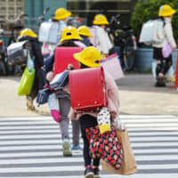 Sudden last day: Students leave school with many bags on Feb. 28 after it was announced that schools in Japan would close in March to try to stop the spread of the new coronavirus. | KYODO