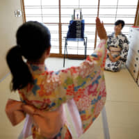 A mother and daughter take an online dance lesson in their Tokyo home March 17. | REUTERS