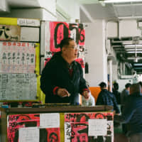 Like \"god\": A tipster solicits business at the Heiwajima kyōtei stadium; boat racing is one of only four sports you can bet on in Japan. | MIKE SUNDA