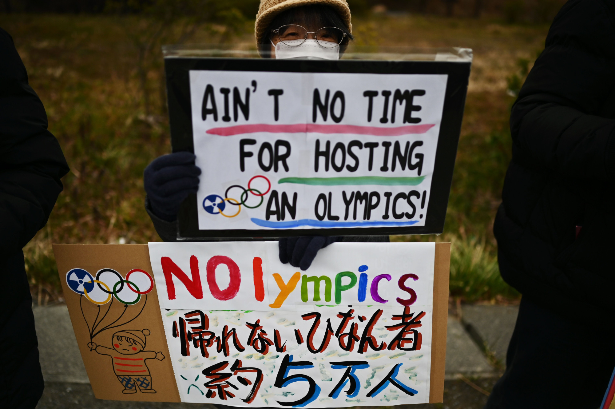 A woman protests against the Olympics and the government's nuclear energy policy Feb. 29 in Naraha, Fukushima Prefecture, where the Olympic torch relay begins this month. | AFP-JIJI