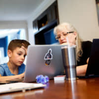 Caidence Miller, a fourth grader in Woodinville, Washington, and his grandmother try to figure out how to navigate his school\'s online learning system on March 11. | REUTERS