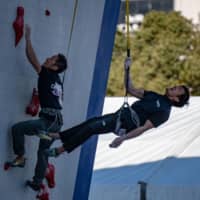Tokyo 2020 organizing staff climb a wall during a speed climbing test at Aomi Urban Sports Park on Friday in Tokyo\'s Koto Ward. | AFP-JIJI