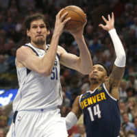 The Mavericks\' Boban Marjanovic takes the ball inside as the Nuggets\' Gary Harris defends in the second half on Wednesday in Dallas. | AP