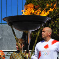 The Olympic flame is seen during a ceremony in Sparta, Greece, on Friday. | REUTERS