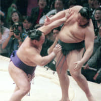 Kotonishiki (left), the then-No. 12 maegashira, defeats yokozuna Takanohana on the 13th day of the Kyushu Grand Sumo Tournament en route to winning his second Emperor\'s Cup in December 1998. | KYODO