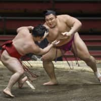 Asanoyama (right) wrestles Enho during Day 10 of the Spring Grand Sumo Tournament on March 17 in Osaka. | KYODO