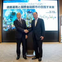 Hiroshi Nakaso, chairman of FinCity.Tokyo and former deputy governor of the Bank of Japan (left) shakes hands with Toshihide Endo, commissioner of the Financial Services Agency, during the FinCity Global Forum at the Grand Hyatt Tokyo, Roppongi, in Tokyo’s Minato Ward on March 19. | ©︎FINCITY.TOKYO