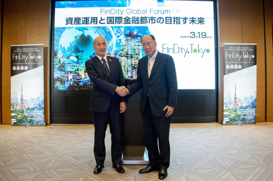 Hiroshi Nakaso, chairman of FinCity.Tokyo and former deputy governor of the Bank of Japan (left) shakes hands with Toshihide Endo, commissioner of the Financial Services Agency, during the FinCity Global Forum at the Grand Hyatt Tokyo, Roppongi, in Tokyo’s Minato Ward on March 19. | ©︎FINCITY.TOKYO