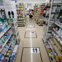 Footmarks indicate where customers should stand to keep distance from each other when in line amid the spread of the new coronavirus, at a Seven-Eleven convenience store in Tokyo on April 13. | REUTERS