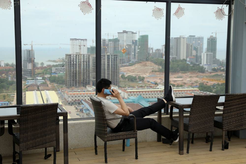 A man speaks on his phone on the rooftop of Chinese businessman Kang Quiang's casino Dong Yuan, in Sihanoukville, Cambodia, on Feb. 28. | REUTERS