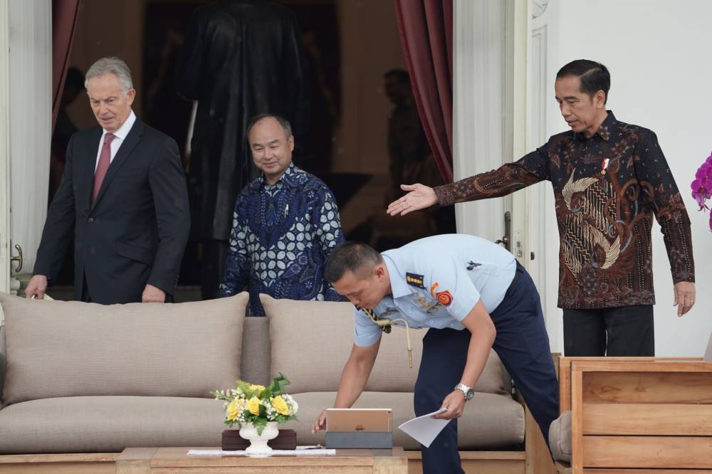 Indonesian President Joko 'Jokowi' Widodo meets with Masayoshi Son, chairman and chief executive officer of SoftBank Group Corp., and Tony Blair, the U.K.'s former prime minster, at Merdeka Palace in Jakarta on Feb. 28. Jokowi's ambitious plan to build a new capital gathered momentum with Son and Blair holding discussions on the contours of the $34 billion project.  | BLOOMBERG