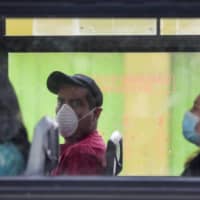 Commuters wear masks as they ride a bus to prevent the spread of the new coronavirus in Mexico City on Tuesday, March 31, 2020. | AP