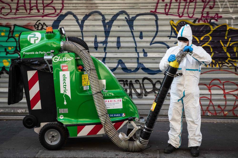 A Paris sidewalk is cleaned on Tuesday, the 15th day of a lockdown aimed at curbing the spread of COVID-19. | AFP-JIJI