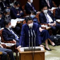 Japan\'s Prime Minister Shinzo Abe wears a protective face mask as he attends an Upper House parliamentary session on April 1. | REUTERS