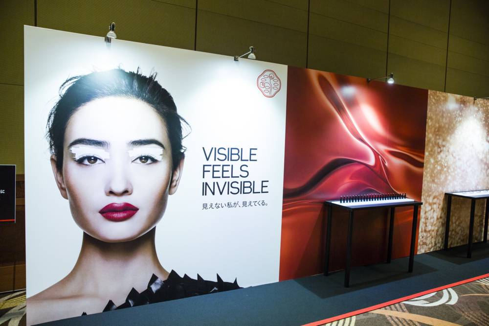 An advertisement for a Shiseido Co. makeup line, left, is displayed at the company's news conference in Tokyo in August 2018. | BLOOMBERG