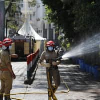 Fire officers disinfect an area in Nizamuddin, from where several people who attended an Islamic congregation earlier this month  tested positive for COVID-19, in New Delhi on Thursday. | AP