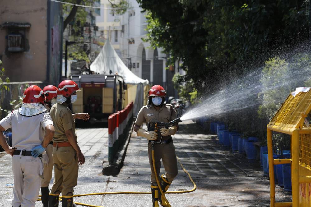 Fire officers disinfect an area in Nizamuddin, from where several people who attended an Islamic congregation earlier this month  tested positive for COVID-19, in New Delhi on Thursday. | AP