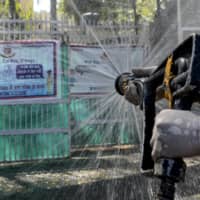 A firefighter disinfects a street near Nizamuddin Markaz mosque during a government-imposed lockdown in New Delhi on Thursday. | AFP-JIJI
