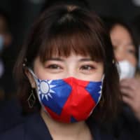 A factory worker wears a face mask with a Taiwanese flag design in Taoyuan, Taiwan, on Monday.  | REUTERS