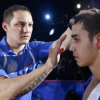 Russian national boxing team coach Anton Kadushin (left) works with a boxer in Sochi, Russia, on April 24, 2014. Kadushin announced Thursday that he has tested positive for the new coronavirus. | AP