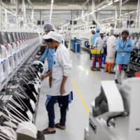 Employees work on an assembly line at a mobile phone plant operated by Rising Stars Mobile India Pvt., a unit of Foxconn Technology Co., in Sriperumbudur, Tamil Nadu, India, in July last year.  | BLOOMBERG
