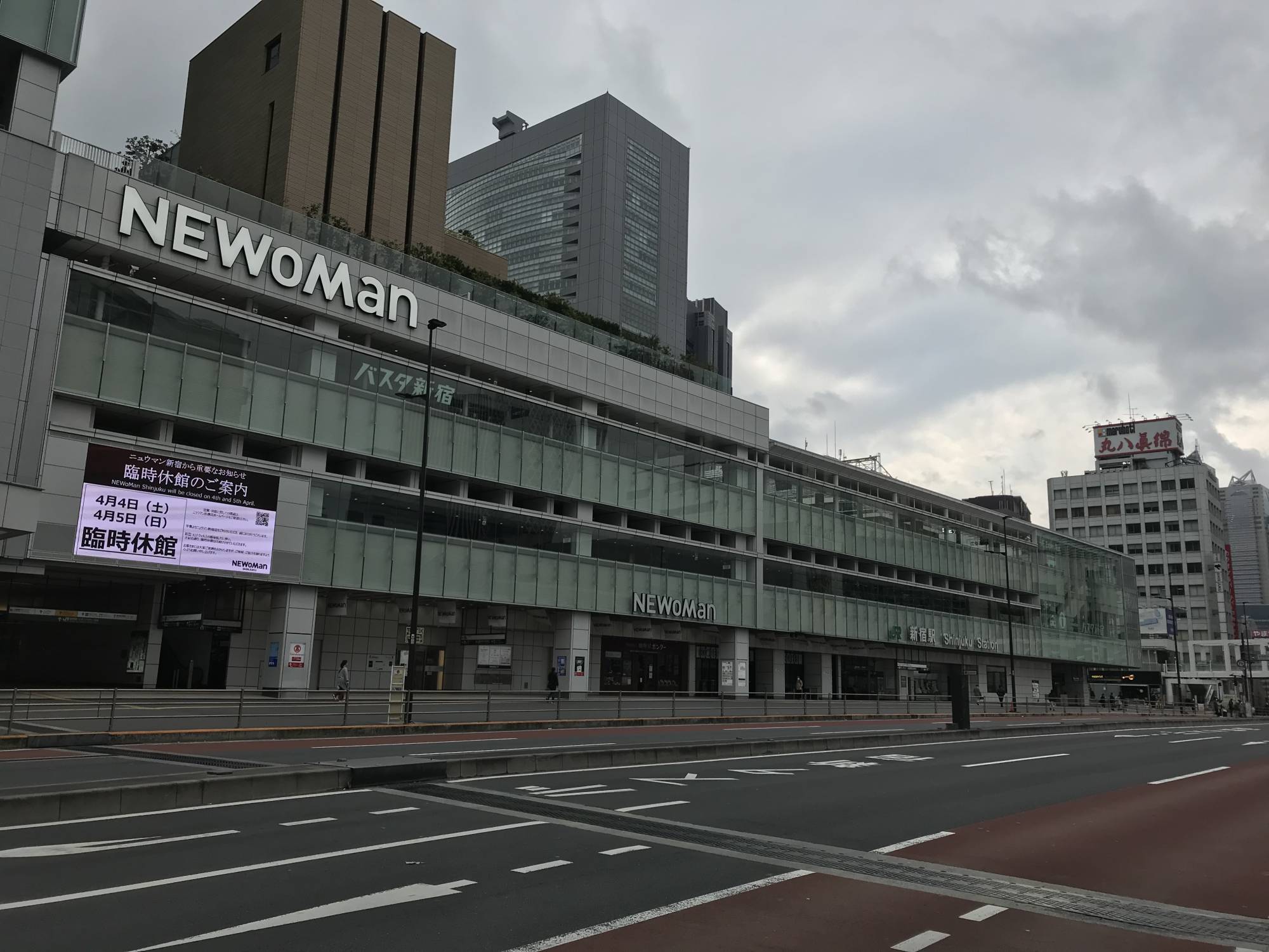 Empty streets: A main thoroughfare outside Tokyo's normally crowded Shinjuku Station is near deserted on a Sunday afternoon. The sign on the Newoman building uses the kanji 臨時休館 (rinji kyūkan), with 'rinji' meaning 'temporary' and 'kyūkan' meaning 'building closure.' | SHAUN MCKENNA