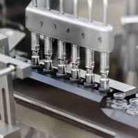 In this March 2020 photo provided by Gilead Sciences, rubber stoppers are placed onto filled vials of the investigational drug remdesivir at a Gilead manufacturing site in the United States. Given through an IV, the medication is designed to interfere with an enzyme that reproduces viral genetic material. | AP