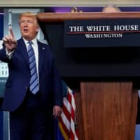 U.S. President Donald Trump stops a reporter from asking Dr. Anthony Fauci a question about use of the drug hydroxychloroquine to treat the disease caused by the new coronavirus at the White House on Sunday. | REUTERS
