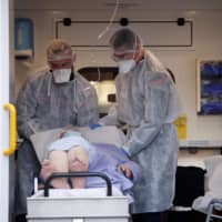 A patient is secured in Strasbourg as the spread of the coronavirus disease continues in France on March 28.  | REUTERS