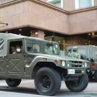 Self-Defense Forces vehicles arrive at a Toyoko Inn in Tokyo on Tuesday to assist the hotel in accepting COVID-19 patients. | RYUSEI TAKAHASHI
