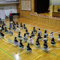 Children attend the entrance ceremony of an elementary school in Nagoya on Monday. | GETTY IMAGES
