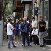 People stand in a line outside a Centrelink office in Sydney on March 26.  |  REUTERS