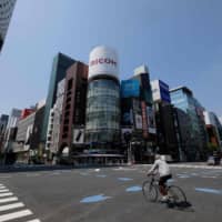 A man riding a bicycle passes a crossing at Tokyo\'s shopping district Ginza on April 8, 2020, on the first day of a state of emergency due to the COVID-19 coronavirus outbreak. | AFP-JIJI