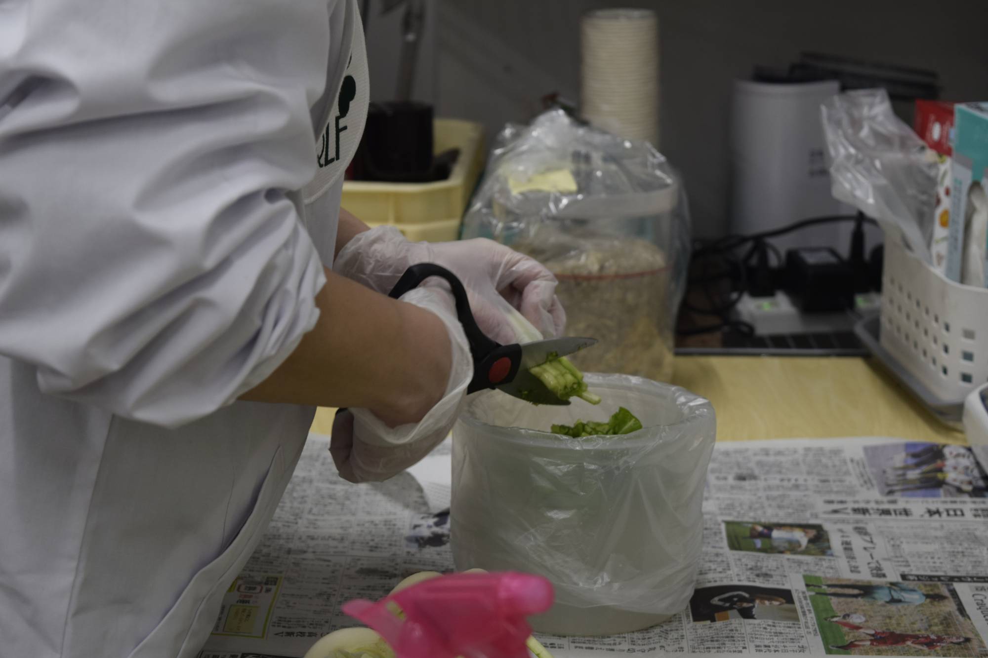 A member of Mothers' Radiation Lab Fukushima cuts green tops off of turnips to measure their radiation level in a lab in Iwaki last month. | KYODO