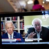 Sen. Bernie Sanders speaks as former Vice President Joe Biden listens during a virtual event on Monday. Sanders endorsed Biden during the joint livestream, saying that Americans of all political affiliations should back the former vice president.  | BLOOMBERG