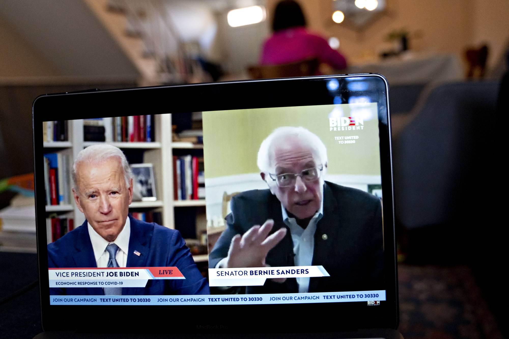 Sen. Bernie Sanders speaks as former Vice President Joe Biden listens during a virtual event on Monday. Sanders endorsed Biden during the joint livestream, saying that Americans of all political affiliations should back the former vice president.  | BLOOMBERG