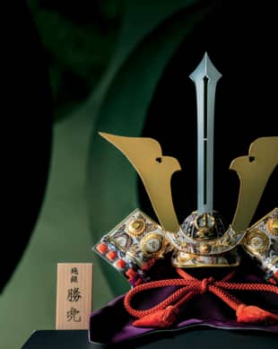 Swordsmith: This pure-silver kabuto helmet, titled 'Ken' ('Sword'), was made by the late Takehiko Seki II, a gold and silver craftsman recognized as a Master of Traditional Arts by the national government. The sword-shaped maedate frontal ornament, traditionally believed to ward off harmful forces, rises straight up. The kabuto helmet embodies hopes that boys will grow up healthy, strong and successful. | JUN NAKAMURA 
