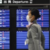 A departure board at Narita Airport near Tokyo shows most flights canceled on April 3 amid the spread of COVID-19. | KYODO
