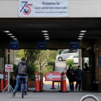 People pass through the main gate of the U.S. Navy Fleet Activities in Yokosuka, Kanagawa Prefecture, on Saturday. | AFP-JIJI