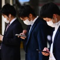 Salary men commute Friday morning in Toko despite the national state of emergency declared the previous day to fight the coronavirus pandemic. | AFP-JIJI