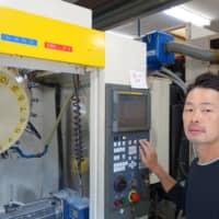 Naoki Kitamori demonstrates how to use one of the machines in his factory in Aoto, a riverside neighborhood in Tokyo\'s Katsushika Ward. | ALEX MARTIN
