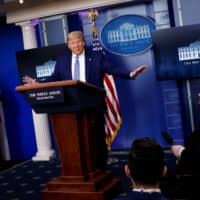 U.S. President Donald Trump speaks as U.S. Vice President Mike Pence listens during the daily COVID-19 task force briefing at the White House on Sunday. | REUTERS
