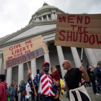Protesters demonstrate against stay-at-home orders at the Capitol building in Olympia, Washington, on Sunday.  | REUTERS