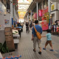 Tourists walk through Ishigaki Island’s Euglena Mall shopping district last month. | THE OKINAWA TIMES
