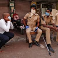 A man holds his ears while doing squats as part of a punishment imposed by the police for breaking a nationwide lockdown in Dharavi on April 11.  | REUTERS 