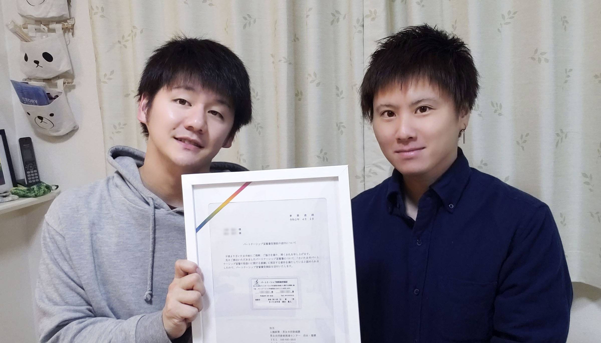 Kohei Inagaki (right) and his partner show their partnership certificate issued by the city of Saitama. | KYODO