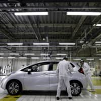 Honda Motor Co. workers make perform a final inspection on a Fit vehicle on the production line at the company\'s Yorii plant in Saitama Prefecture in March 2016.  | BLOOMBERG